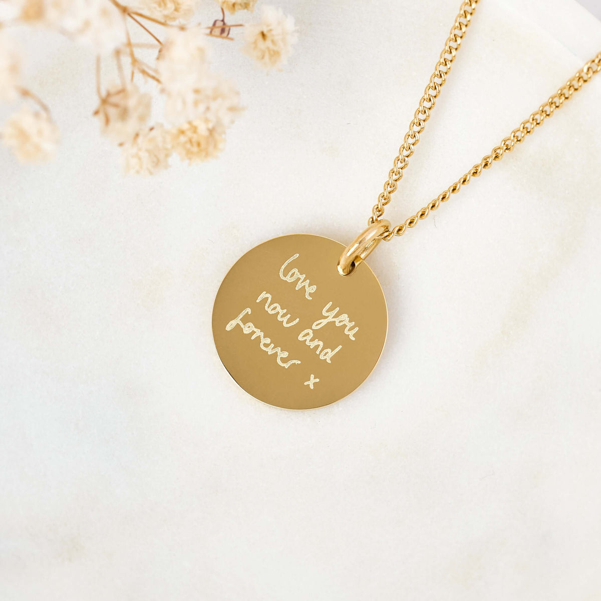 18k gold disc shaped necklace engraved with a loved ones handwriting
