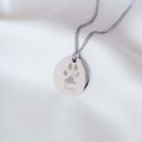 Disc shaped necklace engraved with a paw print