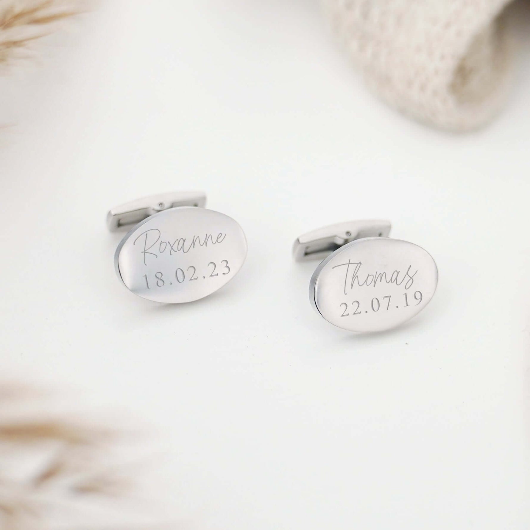 Oval shaped cufflinks etched with a name and date of birth